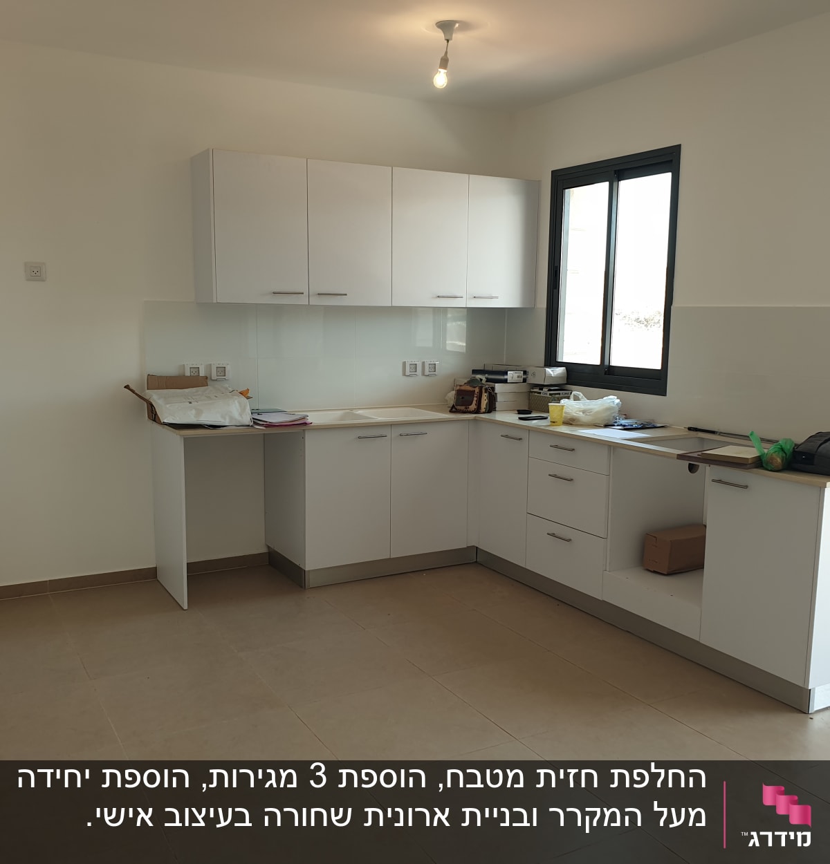מטבח חדש עם ארונות לבנים ומשטח עבודה